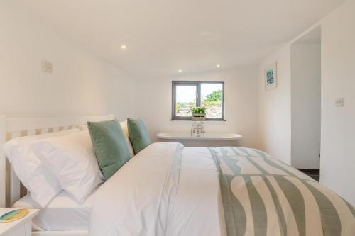 a white bed in a room with a table at 1 Bed in Morwenstow oc-t29298 in Morwenstow
