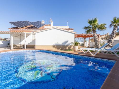 a swimming pool in front of a house at Holiday Home Estrella by Interhome in Riumar