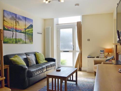 a living room with a couch and a table at Ghillie Cottage in Cockermouth