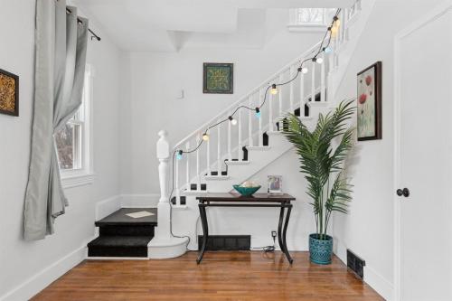 a white staircase with a table and a plant at 3BR Home Across from Como Lake - Aspen in Saint Paul
