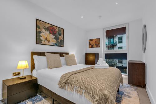 a bedroom with a large bed and a window at MySquare Lanterns Way Apartments at Canary Wharf in London