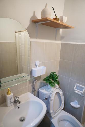 a bathroom with a white toilet and a sink at The Storeys - Mesaverte Residences CDO in Pontud