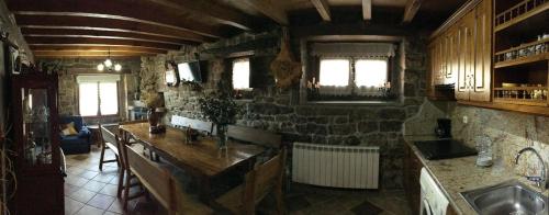 a kitchen with a sink and a stone wall at Casa Miguel in Olea