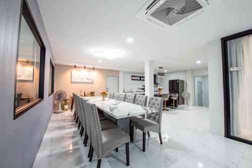 a dining room with a long table and chairs at Tata pool villa pattaya in Jomtien Beach