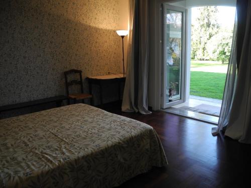 una camera da letto con un letto e una porta scorrevole in vetro di Villa Miani camera floreale a Silea
