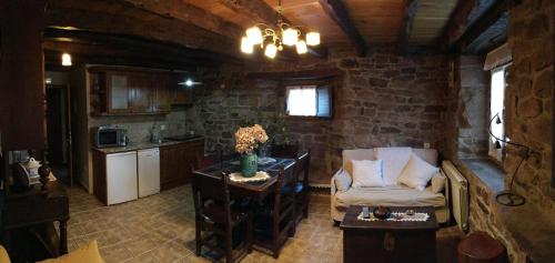a living room with a chair and a kitchen at Casa Miguel in Olea