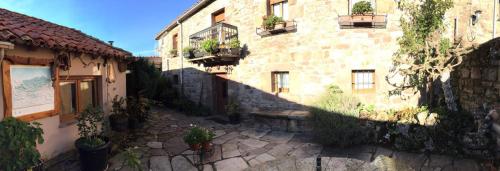 an old stone building with potted plants in a courtyard at Casa Miguel in Olea