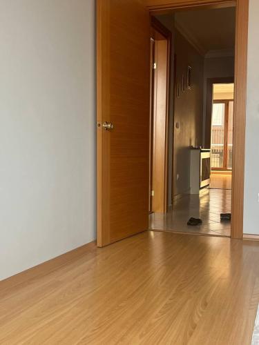an empty room with a wooden door and a kitchen at Nefes Evleri in Istanbul
