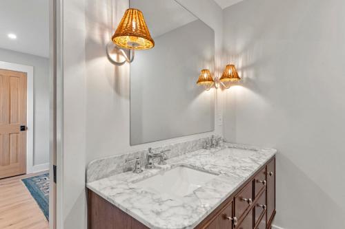 a bathroom with a sink and a mirror at Boots to Beach in Duck