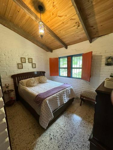 a bedroom with a bed and a wooden ceiling at Ingenia Casa Hostal in Palmira