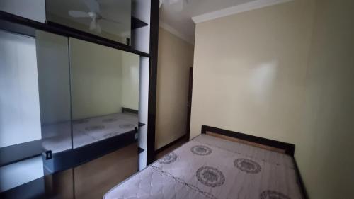 a small room with a bed and a glass wall at Casa dos Vieira in Marataizes