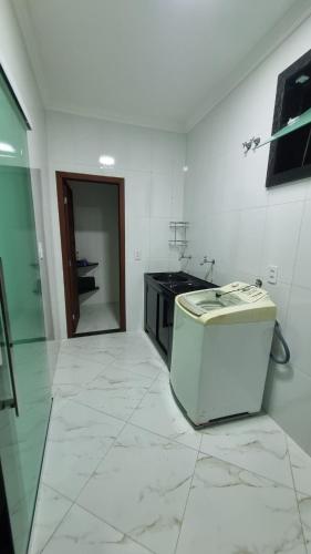 a white kitchen with a stove and a counter at Casa dos Vieira in Marataizes