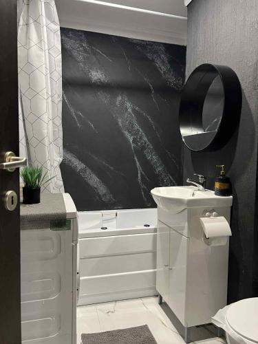 a bathroom with a white tub and a sink and a bath tubermott at city apartament in Oradea