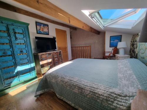 a bedroom with a bed and a flat screen tv at Maison Le Rêve in Evisa