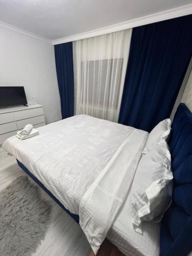 a bedroom with a white bed and a window at city apartament in Oradea