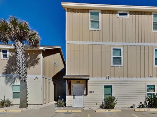 a large building with a palm tree in front of it at Hammonds Reef in Padre Island