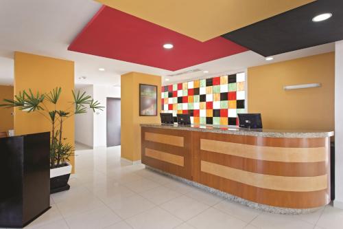 a lobby with a reception desk with a colorful wall at La Quinta by Wyndham Puebla Palmas Angelopolis in Puebla