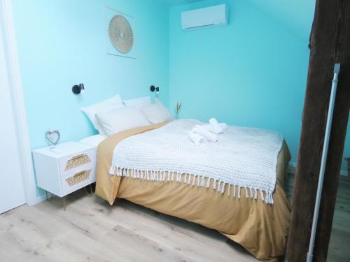 a blue bedroom with a bed with two stuffed animals on it at AlsAppart, duplex climatisé à 5 min de Colmar in Sainte-Croix-en-Plaine