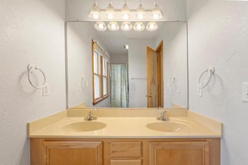 a bathroom with two sinks and a large mirror at Sea Spray in Waves