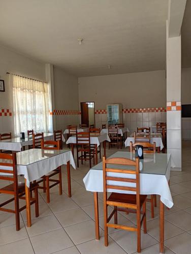 a restaurant with tables and chairs in a room at Pousada Real in Itamonte