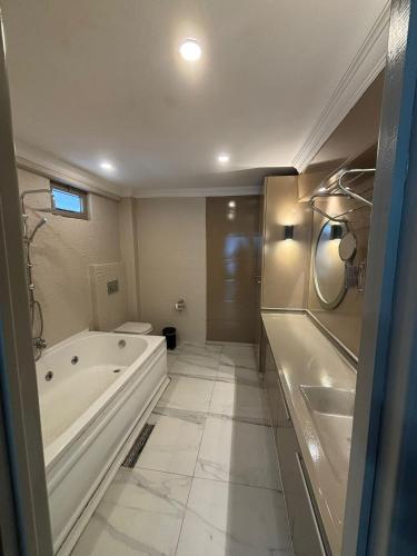 a white bathroom with a tub and a sink at NEW HOTEL SAMSUN in Samsun