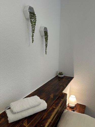 a bedroom with white walls and a wooden table with plants on the wall at Hatzenporter Paradies in Hatzenport