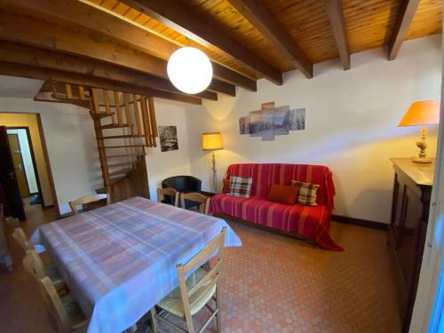 a living room with a table and a red couch at Appartement spacieux en duplex in Saint-Lary-Soulan