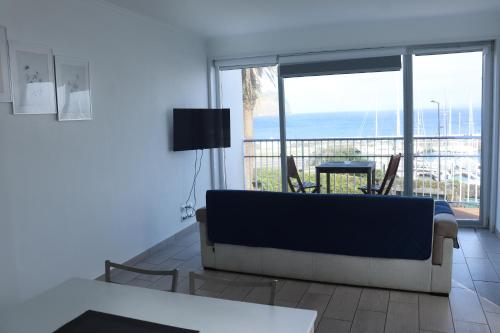 a living room with a couch and a view of the ocean at Faial Marina Apartments 2 in Horta