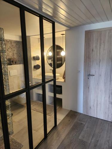 a room with a glass door and a room with a table at Au Bourg in Le Landeron