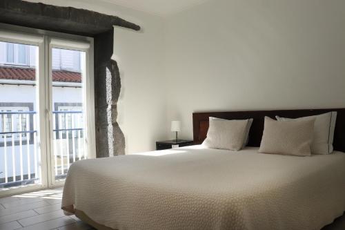 a bedroom with a large bed and a large window at Faial Marina Apartments 2 in Horta