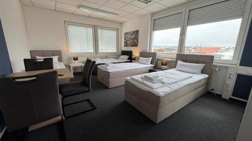 a room with two beds and a table and chairs at J&R Gästezimmer Kassel in Niestetal