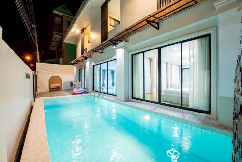 an indoor swimming pool with blue water in a building at Tata pool villa pattaya in Jomtien Beach