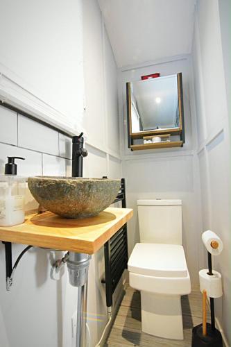 a bathroom with a bowl sink and a toilet at Beautiful shepherd’s hut in Newmarket