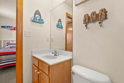 a bathroom with a sink and a toilet and a mirror at HIWA03: Lands End in Waves