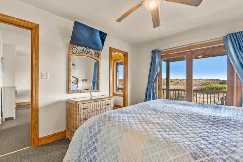 a bedroom with a bed and a large window at HIWA03: Lands End in Waves