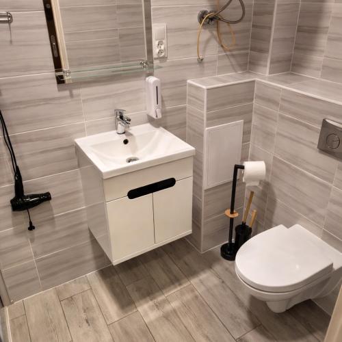 a bathroom with a white sink and a toilet at Apartament Komnata 8 in Przemyśl