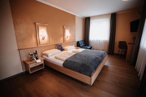 a hotel room with a bed and a chair at Landhaus Schönfelder Hof in Hollfeld