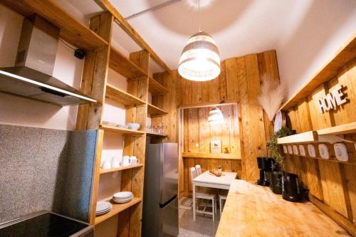 a kitchen with wooden cabinets and a stainless steel refrigerator at BetterBeds Brandenburg in Brandenburg an der Havel