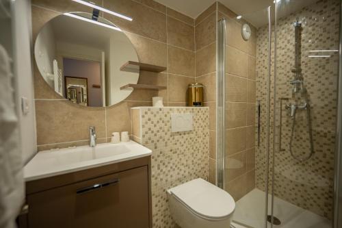 a bathroom with a shower and a sink and a toilet at Hôtel Le Chamois d'Or, USSIM Vacances Méribel in Méribel