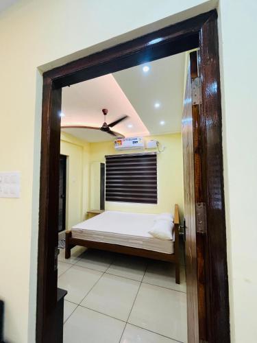 a bedroom with a bed and a window at panakkal tower in Guruvāyūr
