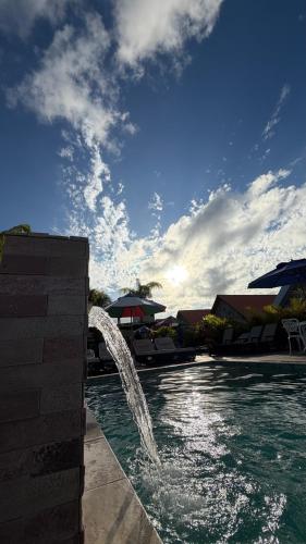 a pool with a water fountain in a resort at Pousada Vila Assu in Ceará-Mirim