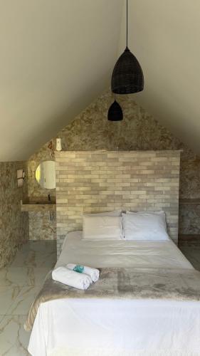 a bedroom with a bed with two towels on it at Pousada Vila Assu in Ceará-Mirim