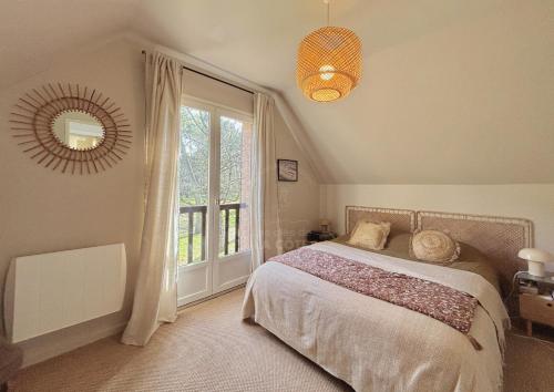 ein Schlafzimmer mit einem Bett und einem großen Fenster in der Unterkunft Maison Bishopswood in Le Touquet-Paris-Plage