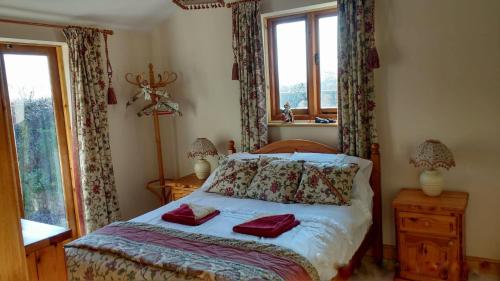 a bedroom with a bed with two red pillows on it at Wolds View in Cornisholme