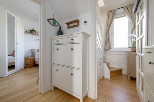 a white chest of drawers in a bedroom with a window at Barnton Grove Getaway in Edinburgh