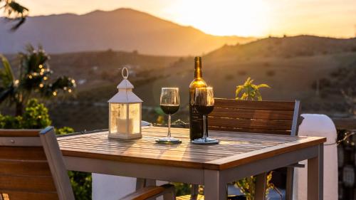 a table with a bottle of wine and two glasses at Finca Gran Cerros in Alora