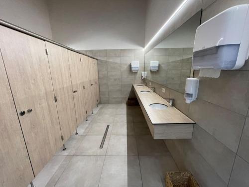 a bathroom with two sinks and wooden cabinets at ARDENNE CAMPING MABOGE in La-Roche-en-Ardenne