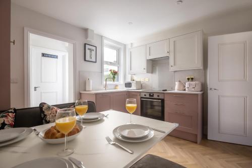 a kitchen with a table with two glasses of wine at The Rosemont in Royal Tunbridge Wells