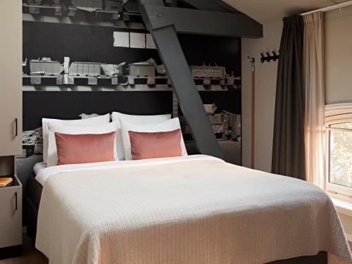 a bedroom with a large white bed with red pillows at YAYS Amsterdam Maritime by Numa in Amsterdam