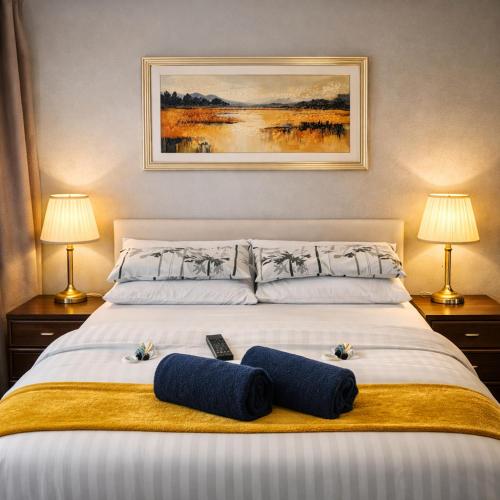 a bedroom with a large bed with two pillows on it at Denville Hotel in Blackpool